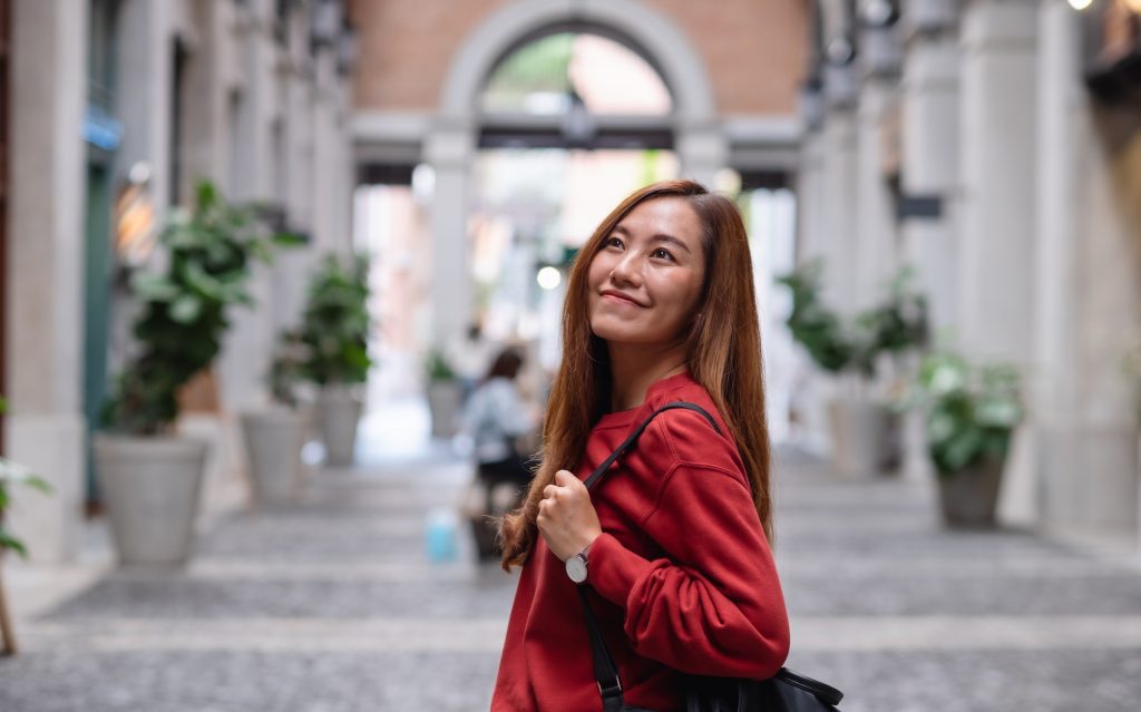 A young asian woman walking on the street while traveling and sightseeing around the city