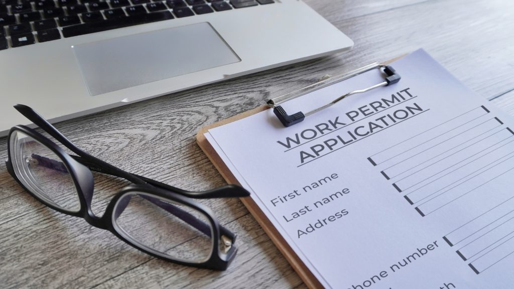 Closeup image of paper clipboard with Work Permit Application form .